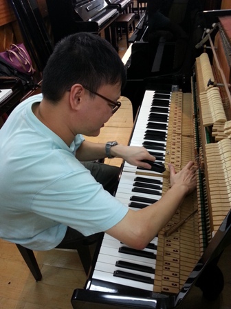 劉鎧澤認真地為客戶調琴