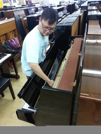 劉鎧澤認真地為客戶調琴